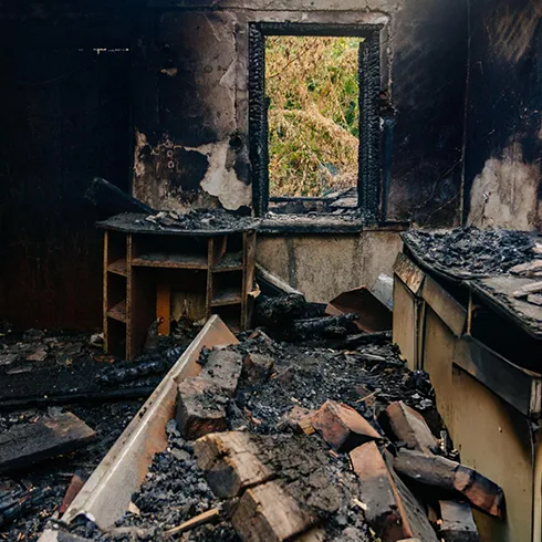 Interior view showing fire-damaged walls and charred structure, emphasizing the need for professional fire damage restoration services.