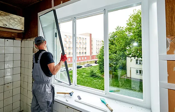 Installer sealing an energy-efficient window, demonstrating energy-efficient window installation services in Henrico, VA.