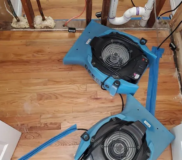 Overview of the water restoration process, featuring equipment in action on a wooden floor, highlighting the challenges and solutions of emergency water damage recovery.