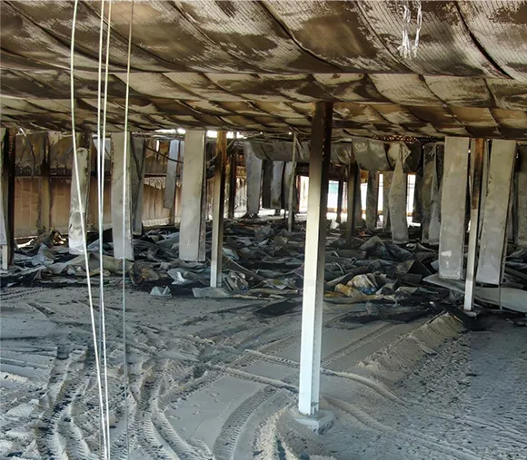Image of an exposed building structure post-fire, highlighting the ongoing fire damage restoration work and the importance of professional repair.