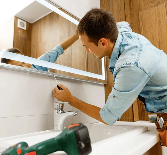 Person organizing items in a luxury kitchen with modern cabinetry and fixtures.